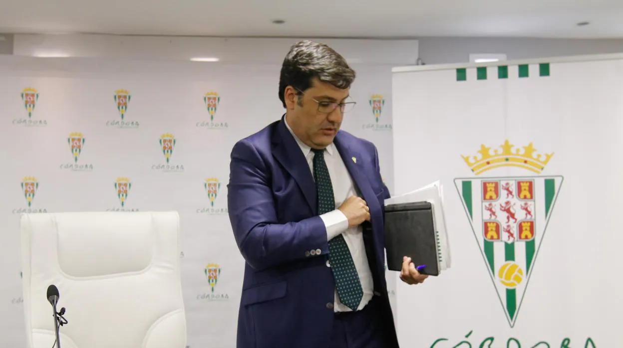 El presidente del Córdoba CF, Jesús León, se mete la mano en el bolsillo interior de la chaqueta