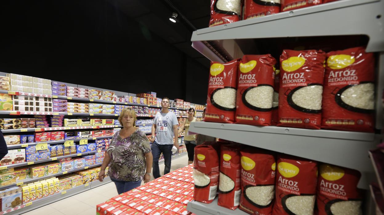 Clientes pasan entre los lineales de un supermercado