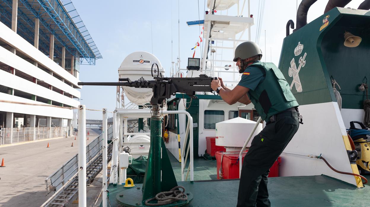 Un agente de la tripulación del «Río Miño», con una de las armas del buque