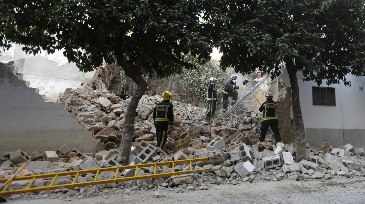 Los bomberos trabajan en el muro derrumbado que afectó a la muralla romana