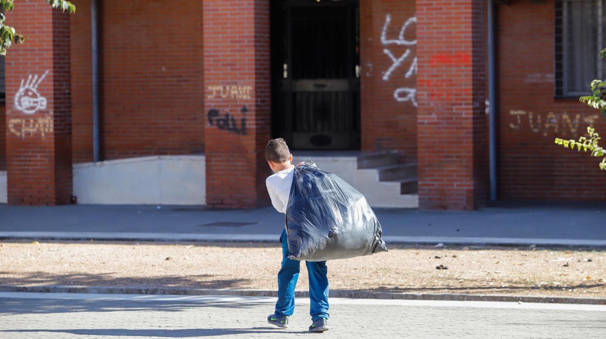 Un menor saca la basura en un patio de Moreras