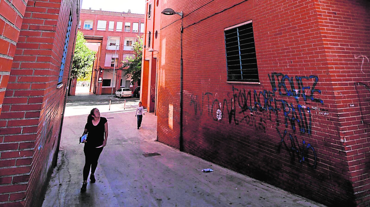 Una mujer observa humedades en un patio de Las Moreras