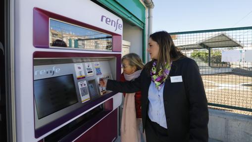 Una usuaria saca su billete, con ayuda de una empleada de Renfe, el día del estreno del tren