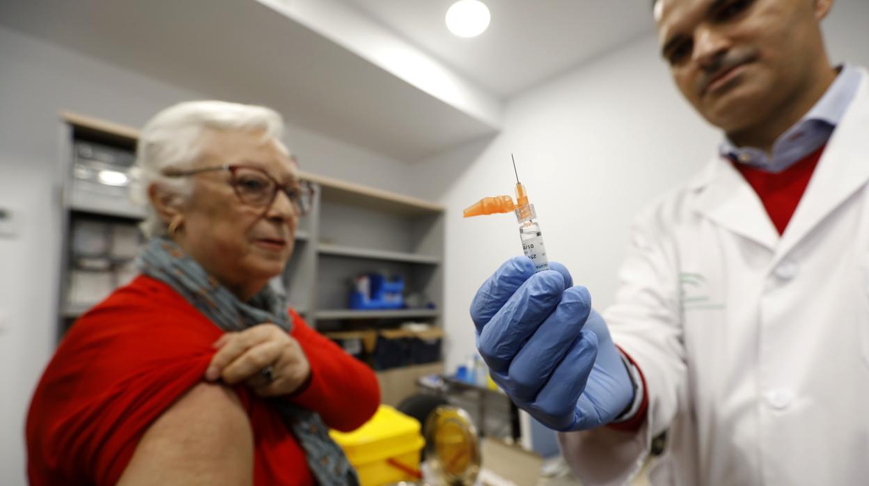 Una señora recibe una dosis de la vacuna de la gripe en esta campaña en un centro de salud de Córdoba