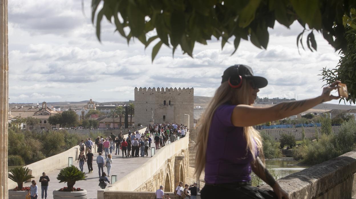 Una mujer se hace un selfie en la Puerta del Puente