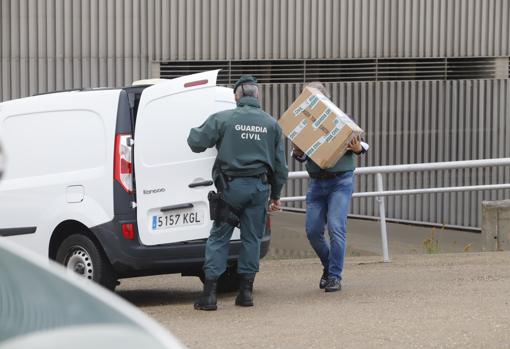 Agentes de la Guardia Civil cargan documentación tras el registro en el Arcángel