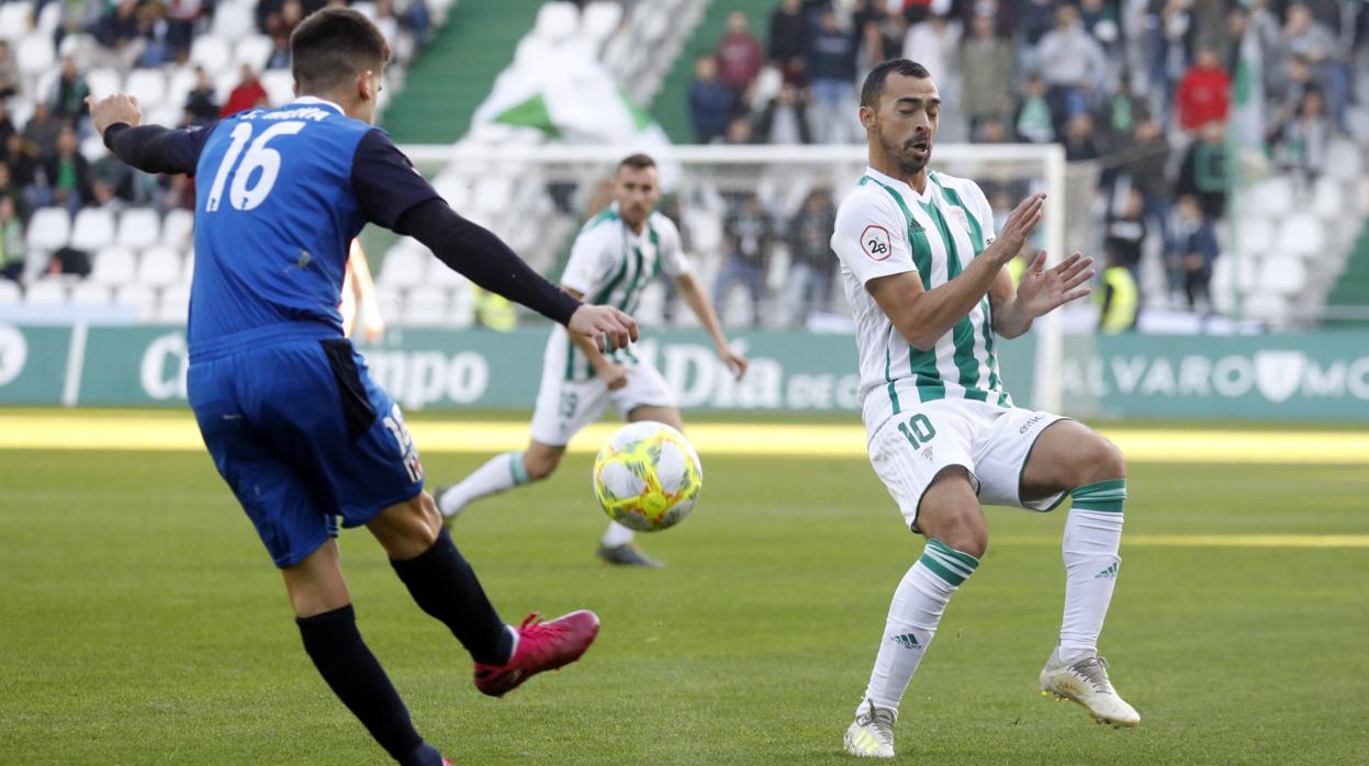 Miguel de las Cuevas, novedad del once del Córdoba ante el Mérida, se protege de un pase de Mena