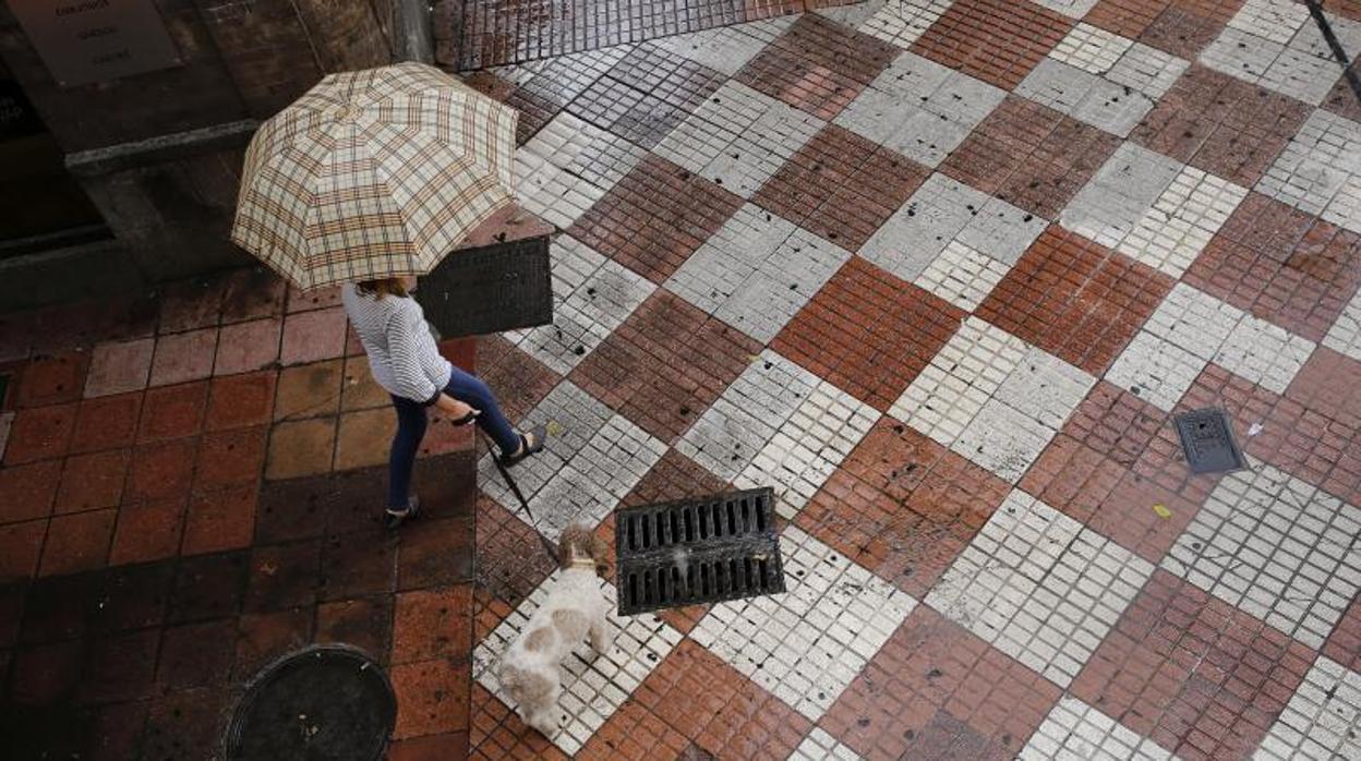 Una mujer cruza con un paraguas por la calle La Plata, en el Centro de Córdoba