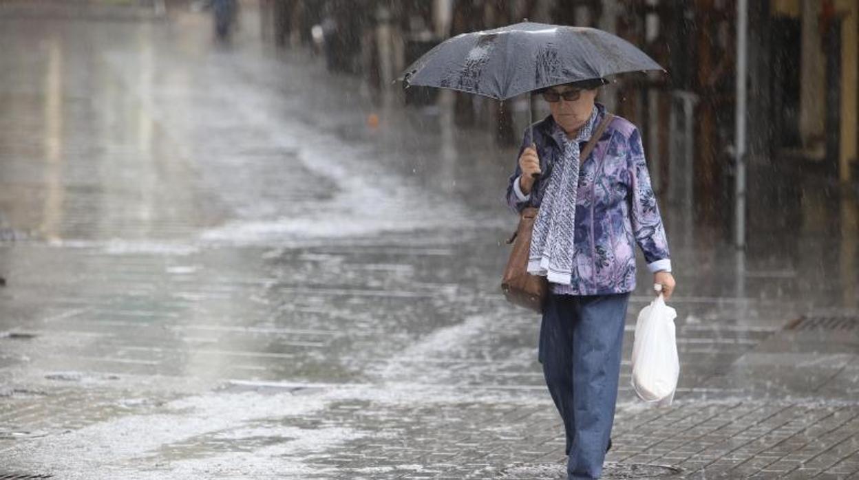 Una mujer camina bajo la lluvia en una calle del Centro de Córdoba