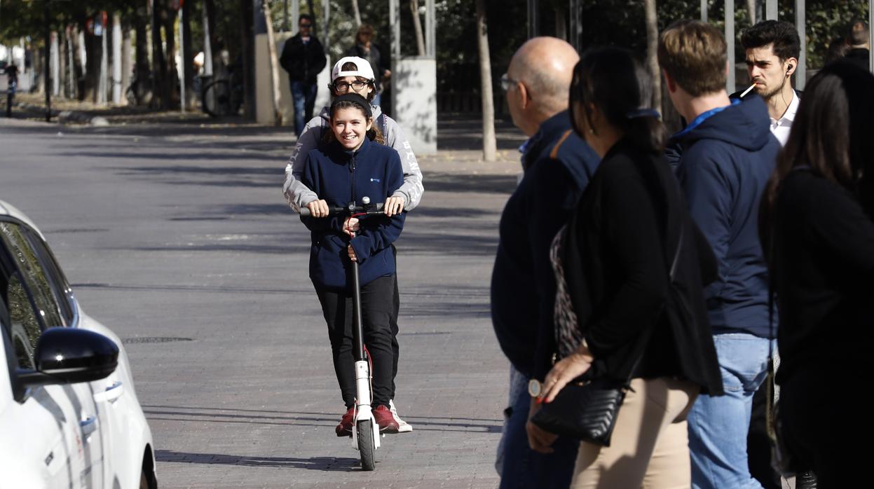 Dos personas circulan en patinete eléctrico por la Ribera