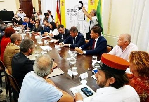 En primer plano, Martínez con el gorro durante una reunón con el ministro Ábalos.