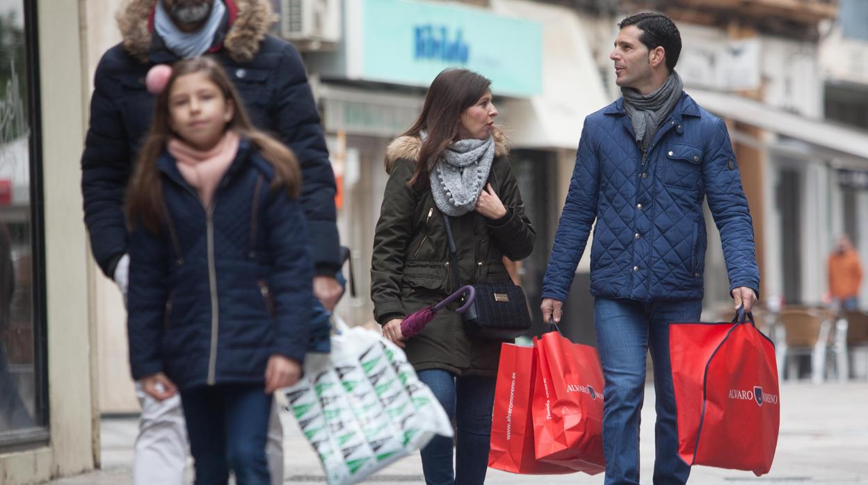 Una familia pasea por el centro en un día de rebajas