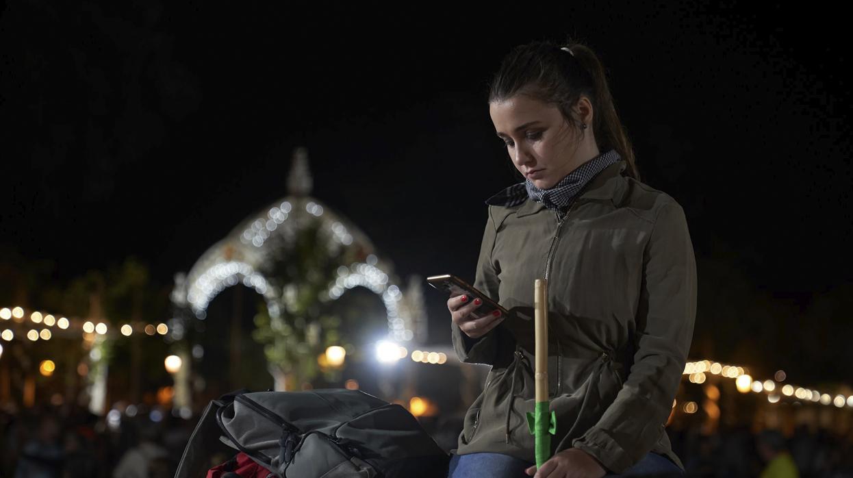 Una peregrina consulta su móvil en la noche del Traslado del pasado año 2019