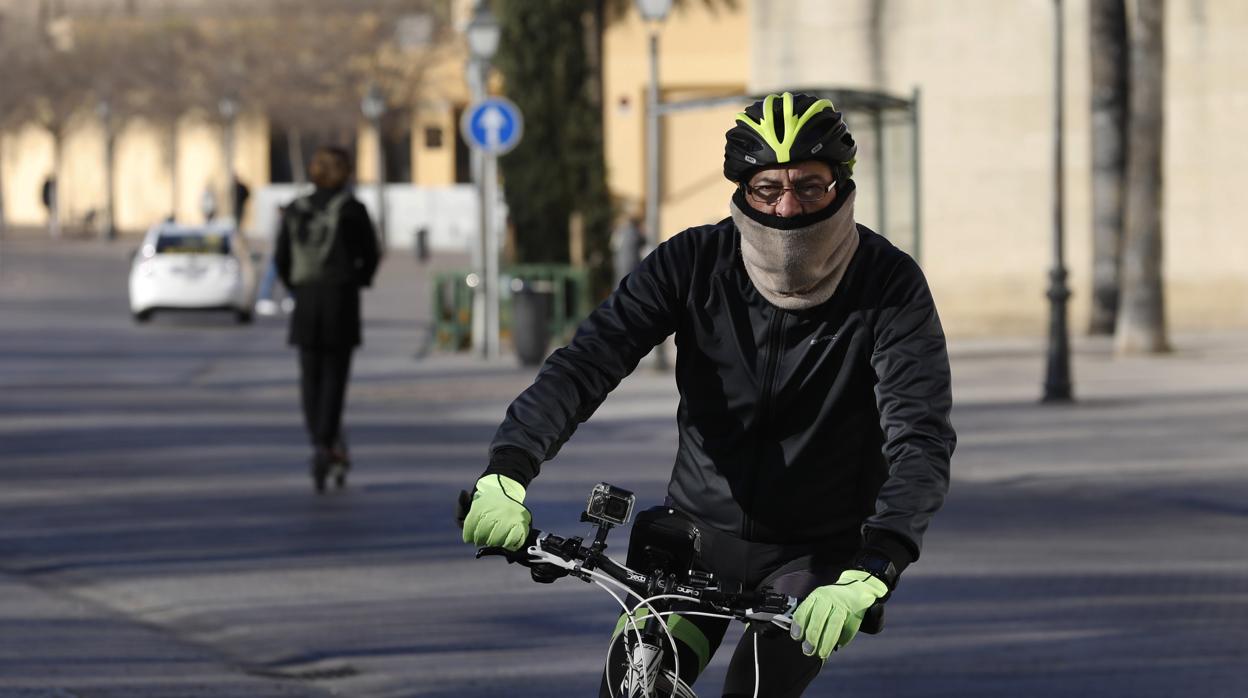 Un ciclista circula con su bicicleta bien abrigado