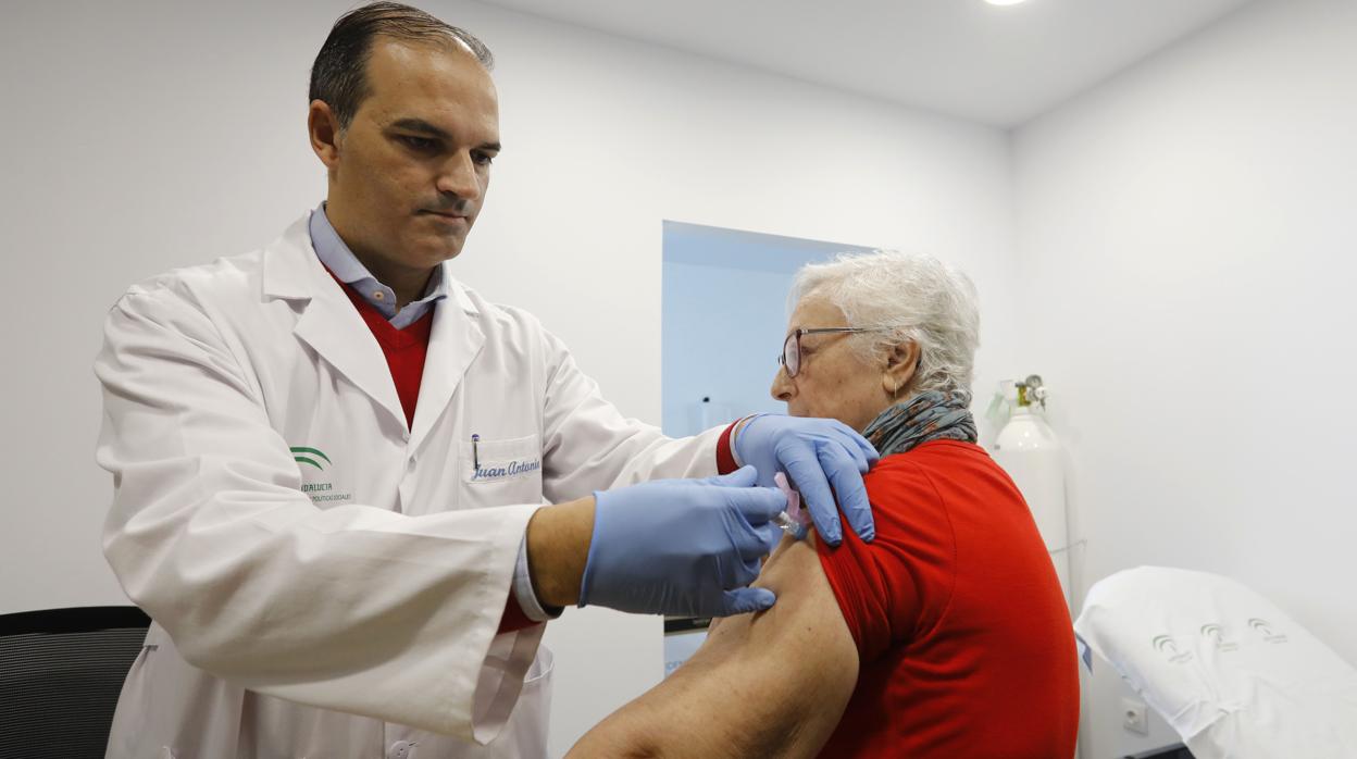 Una mujer r ecibe la vacuna contra la gripe en un centro de salud