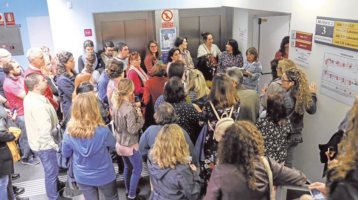 Opositores esperan en la puerta del aula al inicio de una prueba