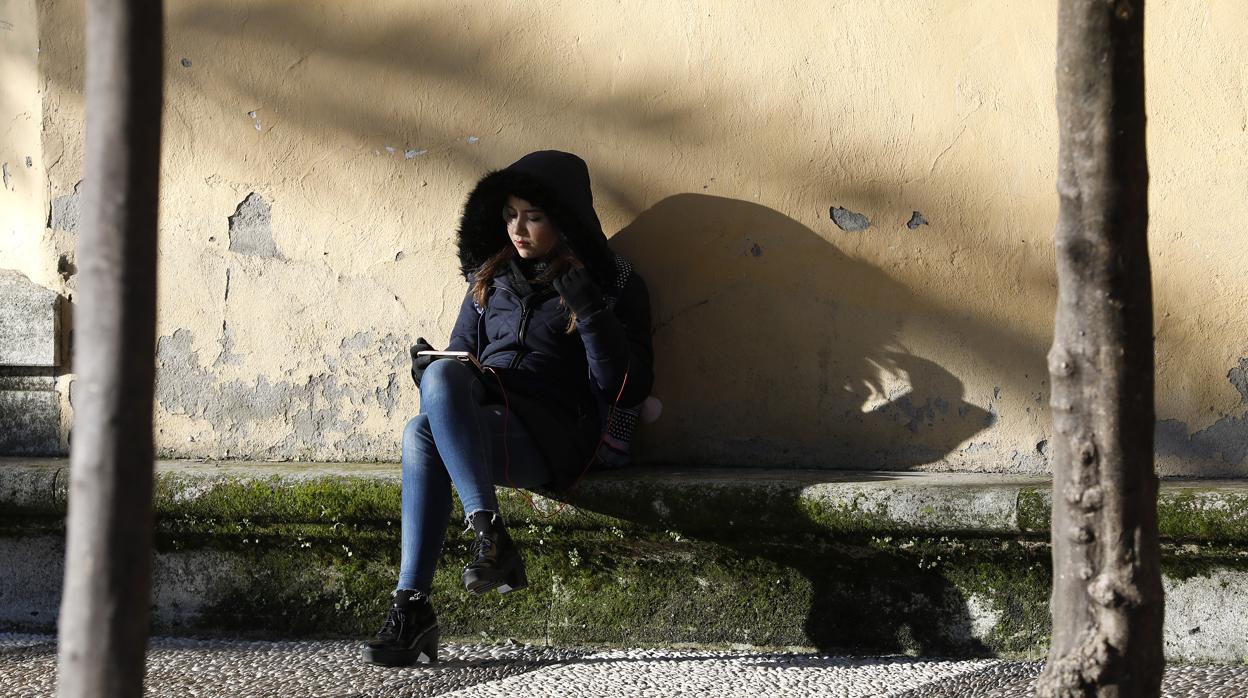 Una joven sentada en un banco en Córdoba