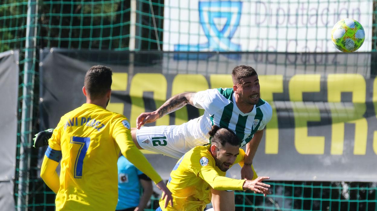 El cordobesista Xavi Molina despeja un balón ante el cadista Javi Pérez