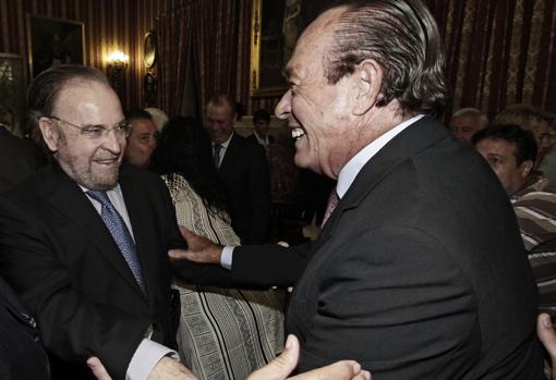 Antonio Burgos y Curro Romero se saludan efusivamente en un acto del Ayuntamiento de Sevilla