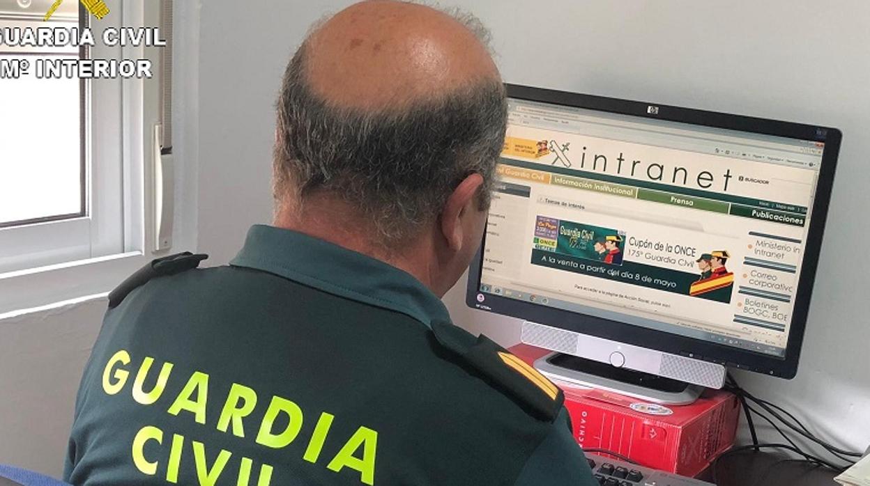 Un agente de la Guardia Civil revissando informaición