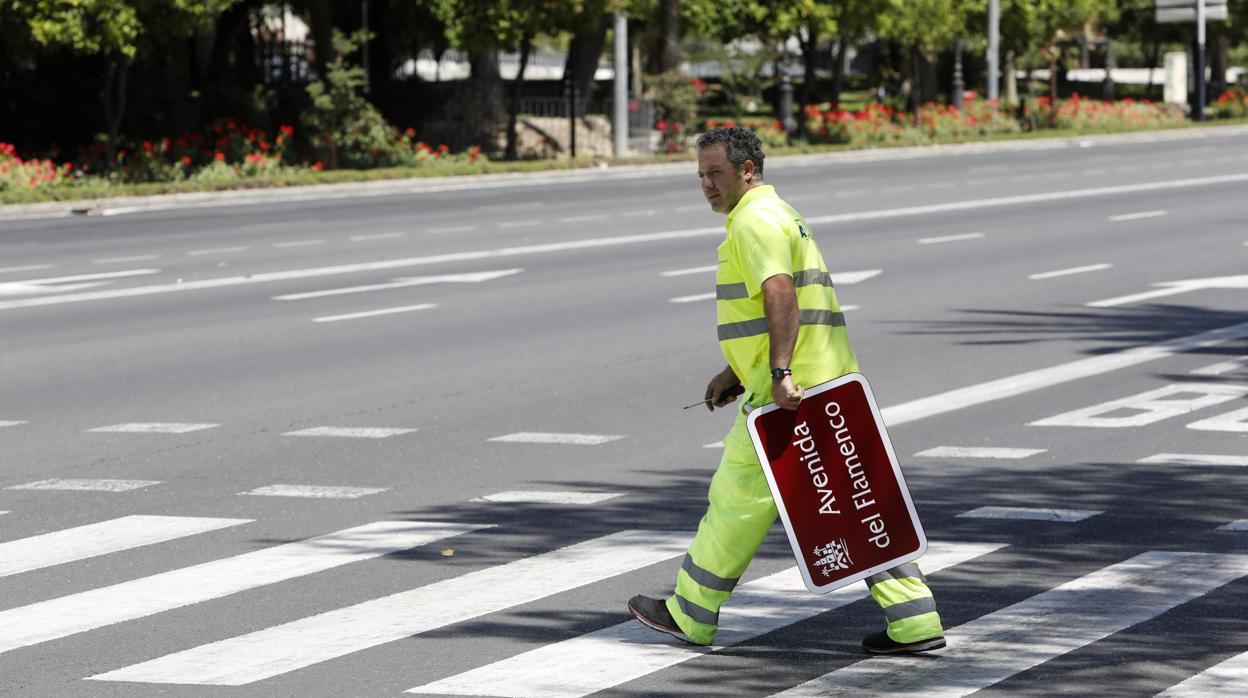 Un operario con el cartel de avenida del Flamenco durante el cambio de nombre a Vallellano