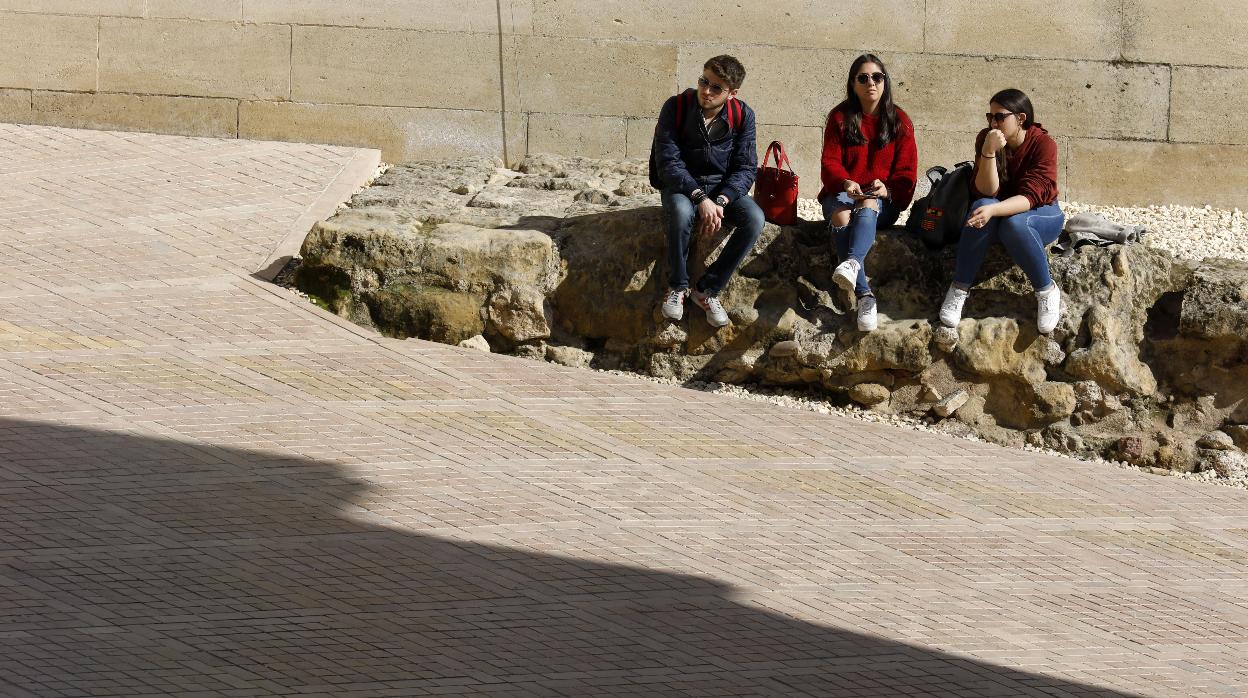 Jóvenes al sol junto a la Puerta del Puente