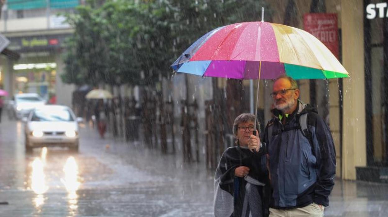 Una pareja bajo la lluvia en la plaza de las Tendillas