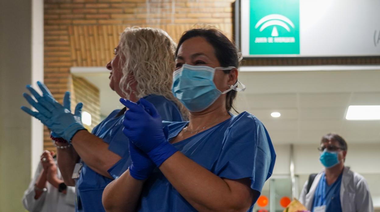 Personal sanitario del hospital Virgen del Rocio de Sevilla aplauden en la puerta de Urgencia del centro