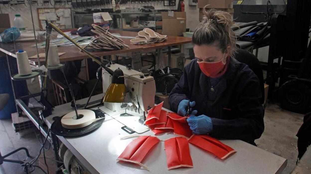 Una mujer fabricando mascarillas