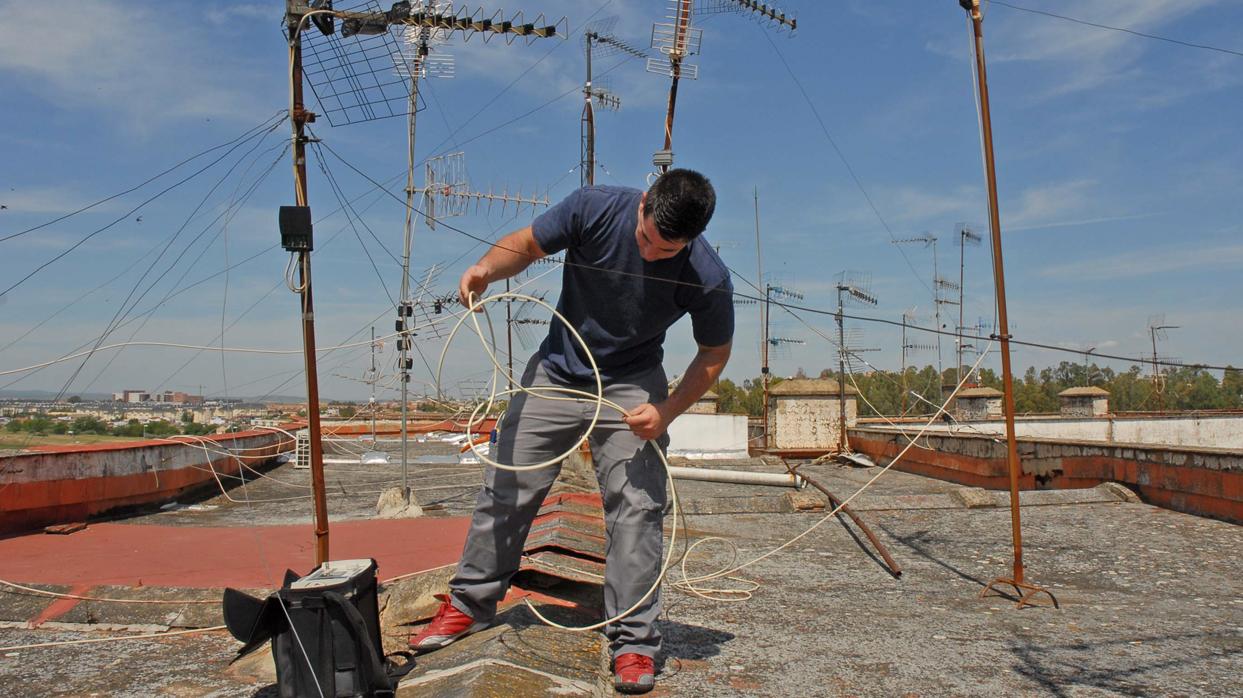 Un técnico especialista en antenas trabaja sobre el tejado de una vivienda