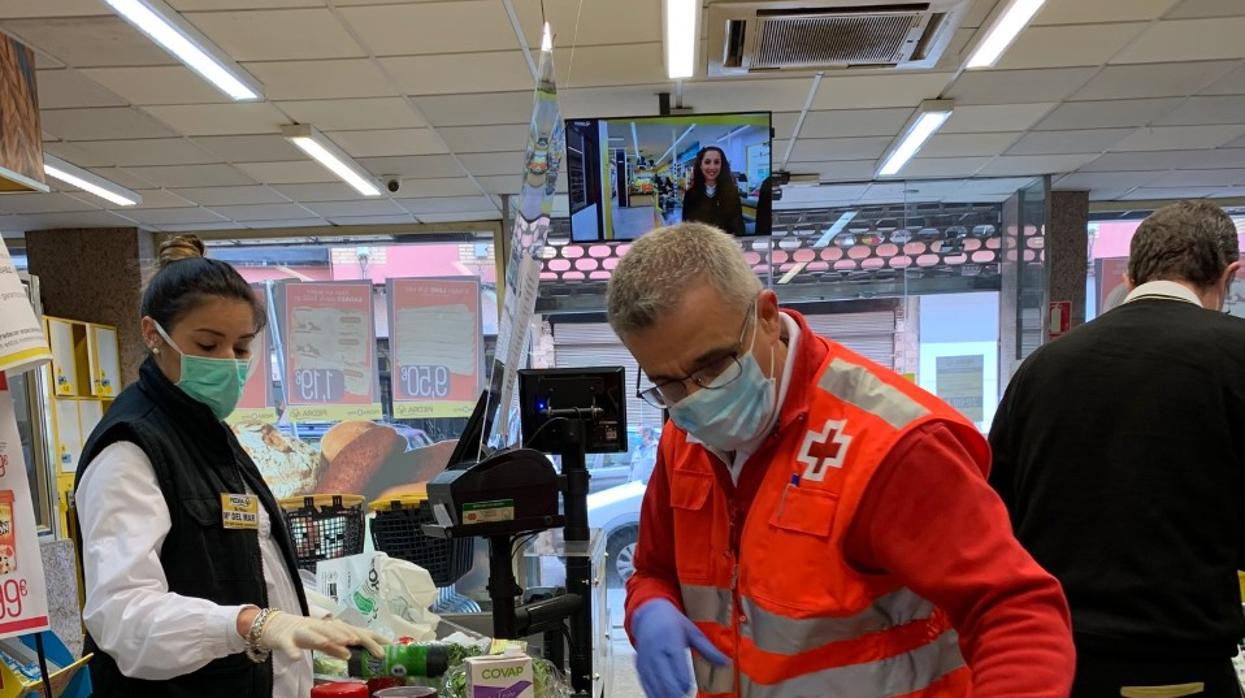 Voluntarios de la Cruz Roja en un supermercado de Córdoba durante la crisis del coronavirus