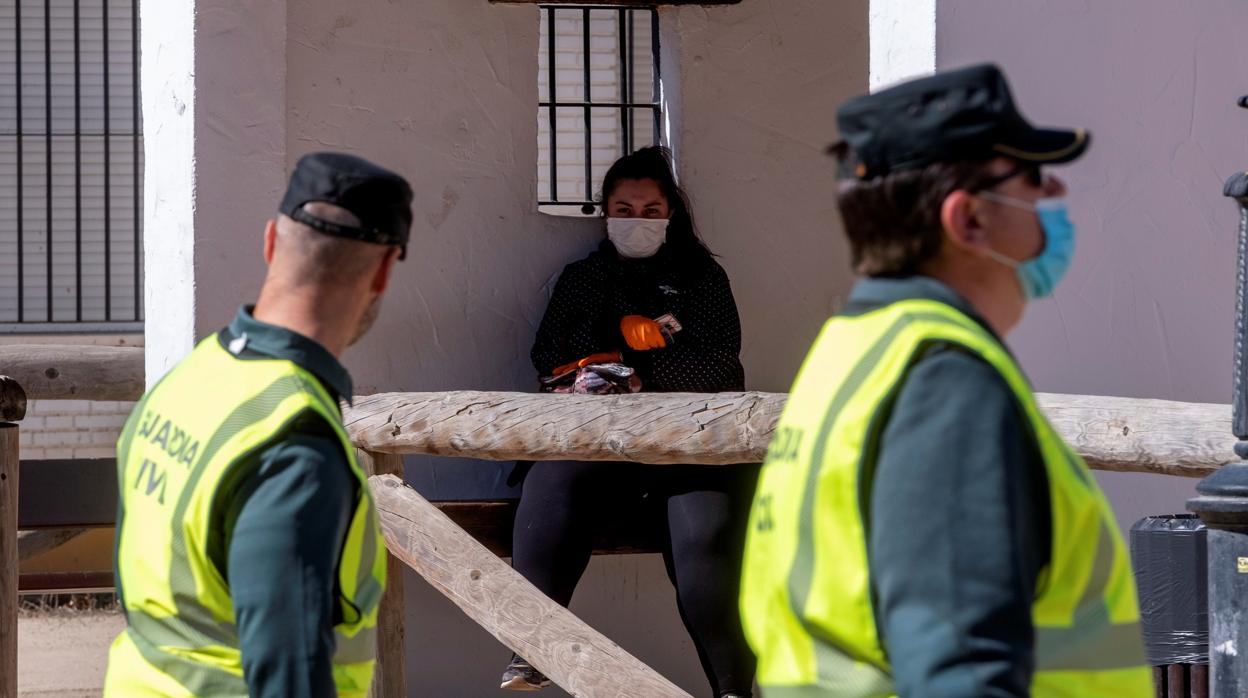 Una mujer espera el autobús en la aldea almonteña de El Rocío