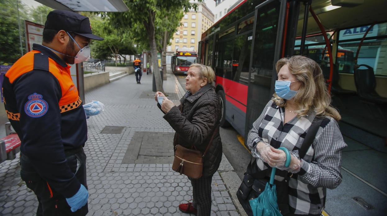 Miembros de Protección Civil reparten mascarillas en Sevilla