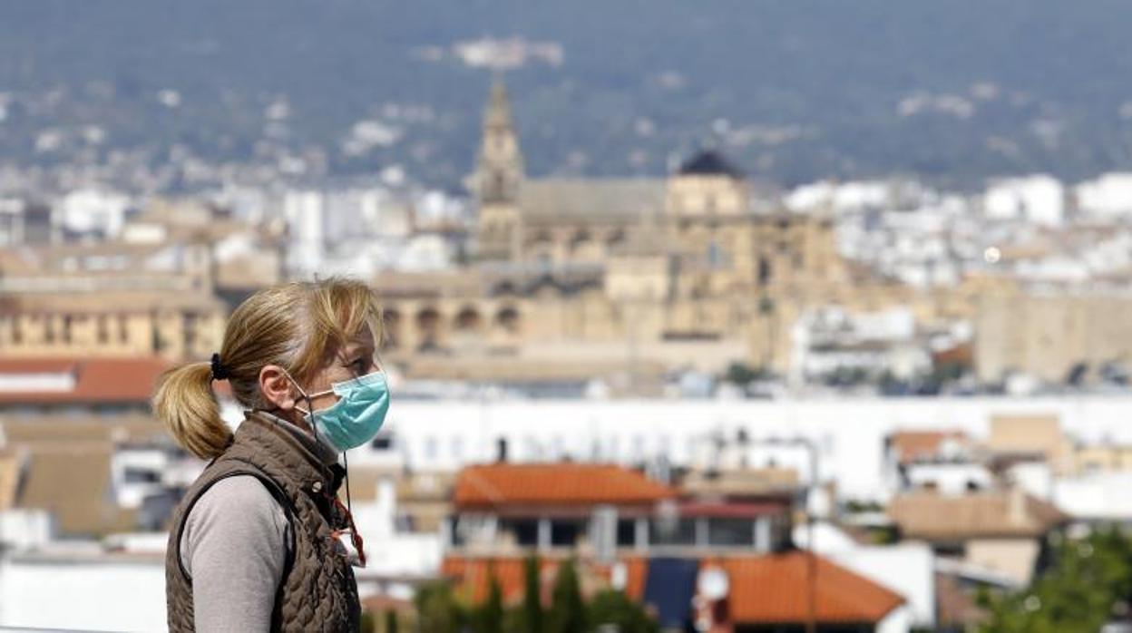 Una mujer con mascarilla camina por un barrio del sur de Córdoba