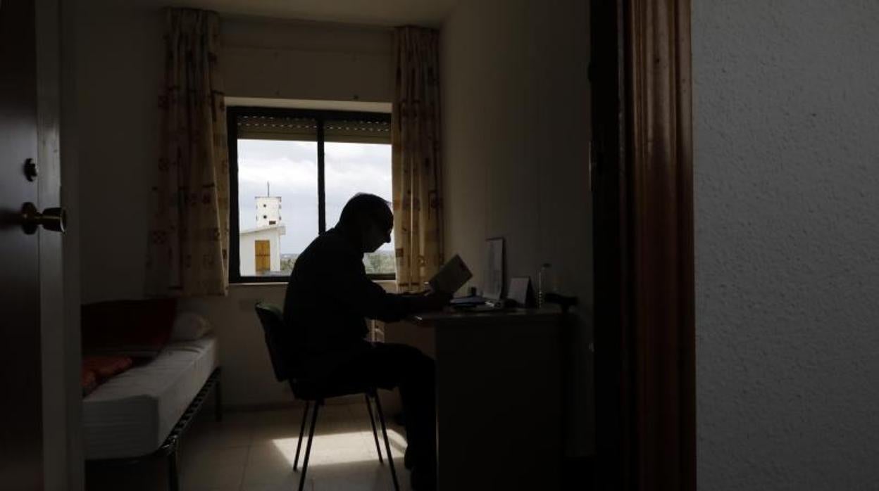 Frnacisco, residente del albergue, lee en su habitación con vistas a la campiña