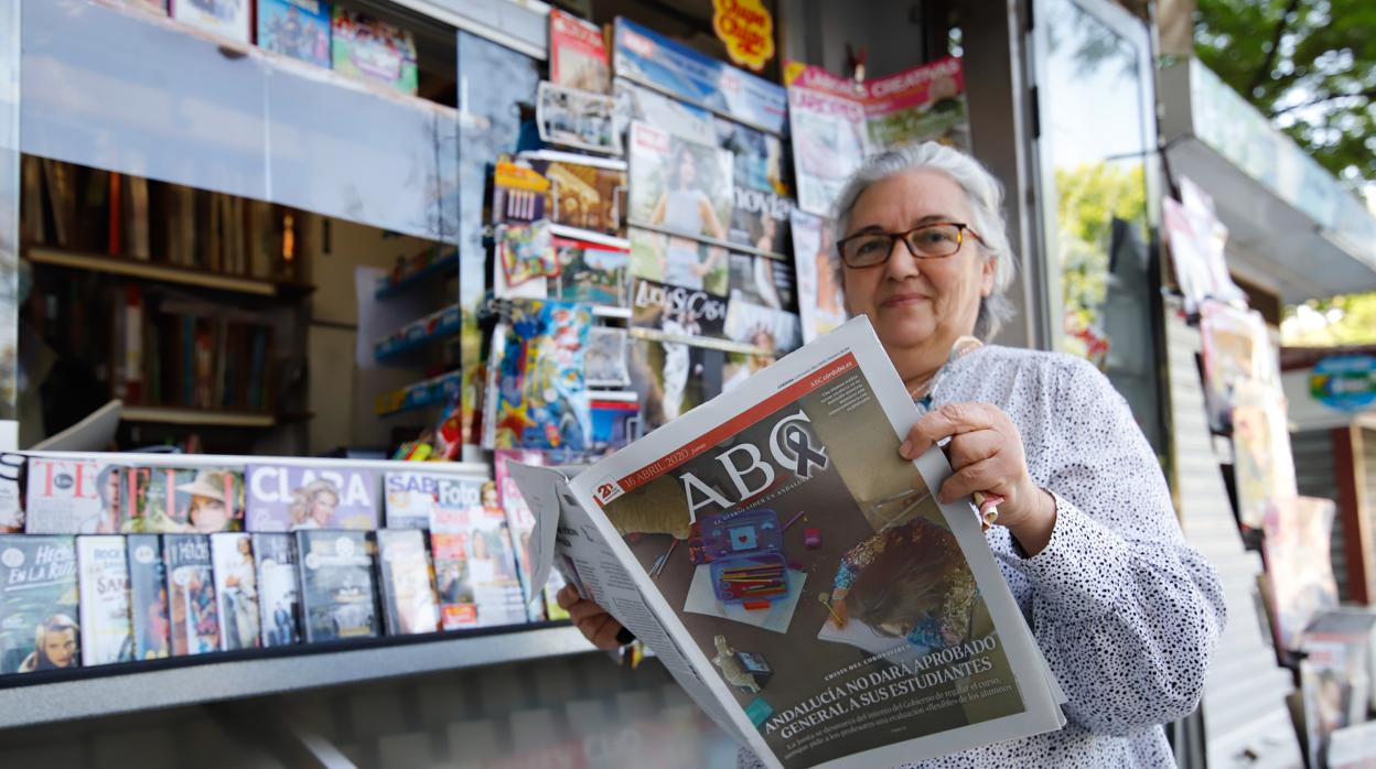 Una mujer lee nuestro periódico delante de un quiosco