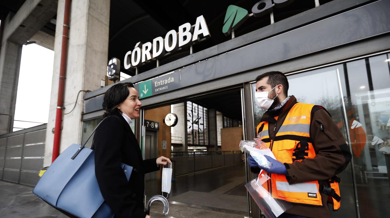 Un operario reparte mascarillas de seguridad a la entrada de la estación del AVE