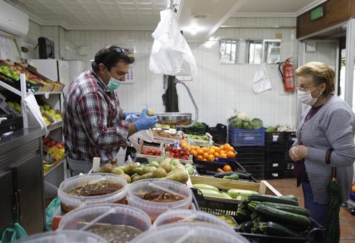 Un hombre atiende a una mujer en una frutería