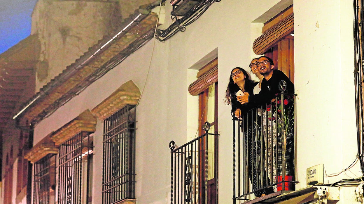 Tres jóvenes disfrutan de las vistas desde su balcón