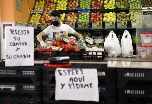 Juan Mengual atienda en su tienda de frutas y verduras