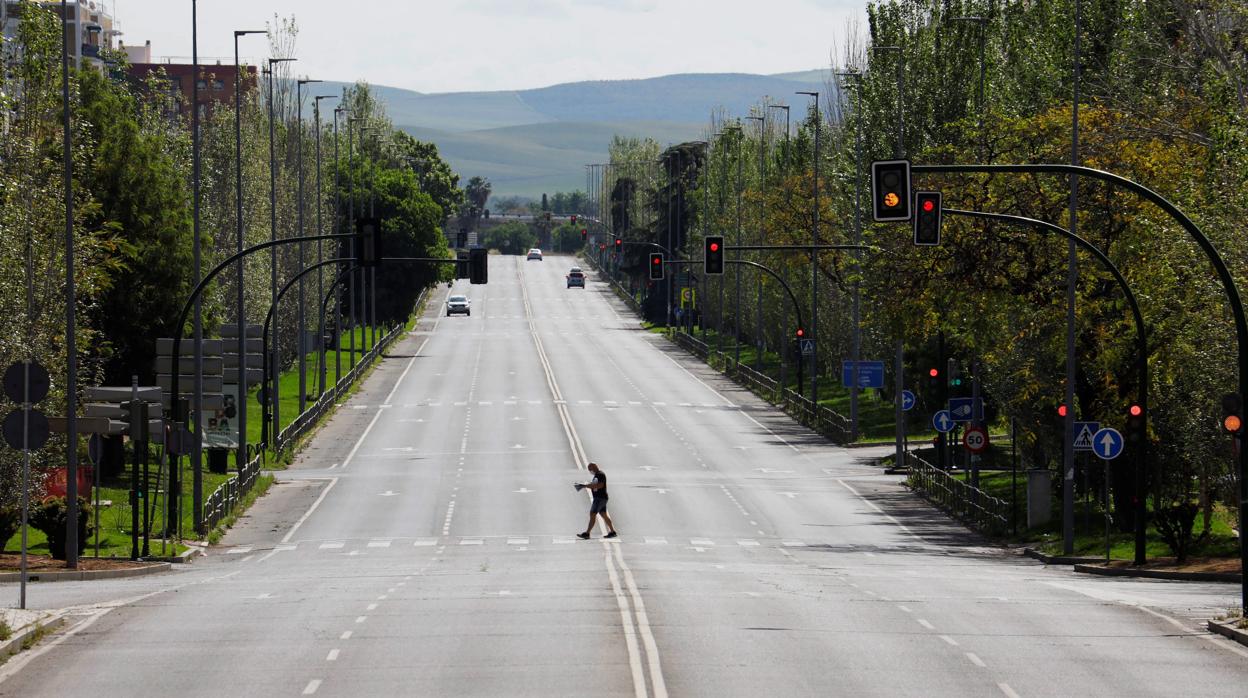 Unhombre cruza la solitaria avenida de Carlos III en Córdoba capital