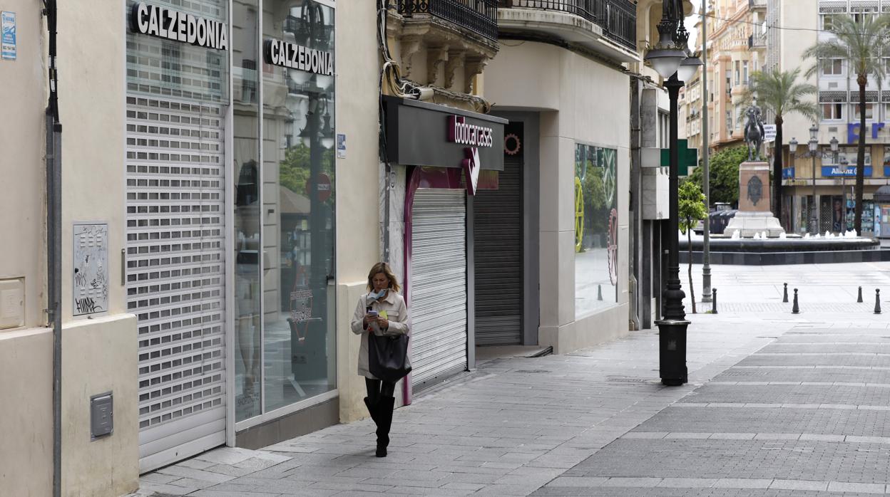 Una mujer pasa por Gondomar, una de las grandes vías comerciales, durante el estado de alarma