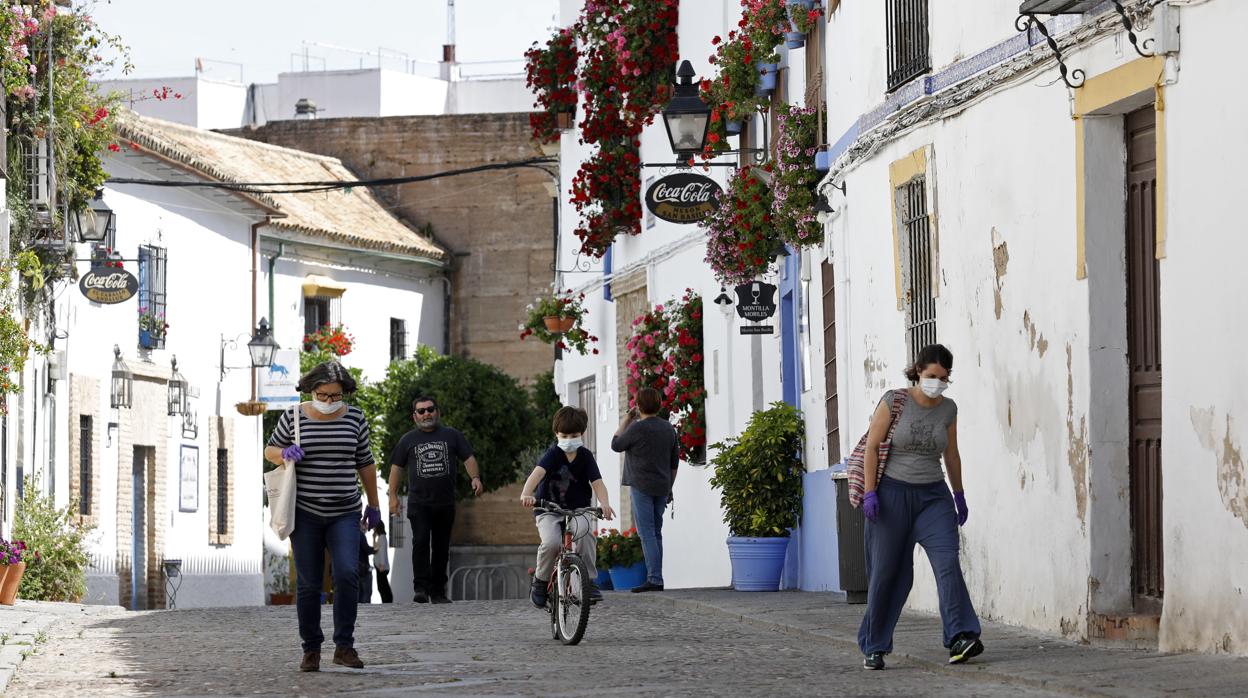 Varios vecinos caminan por la calle central del barrio