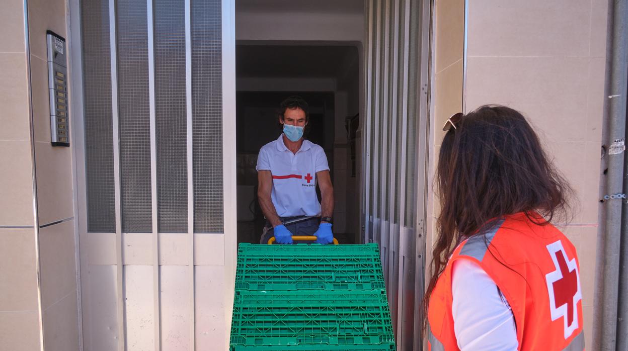 Personal de Cruz Roja entregando productos de primera necesidad en un domicilio