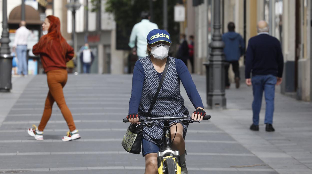 Una mujer en bicicleta por la calle Gondomar