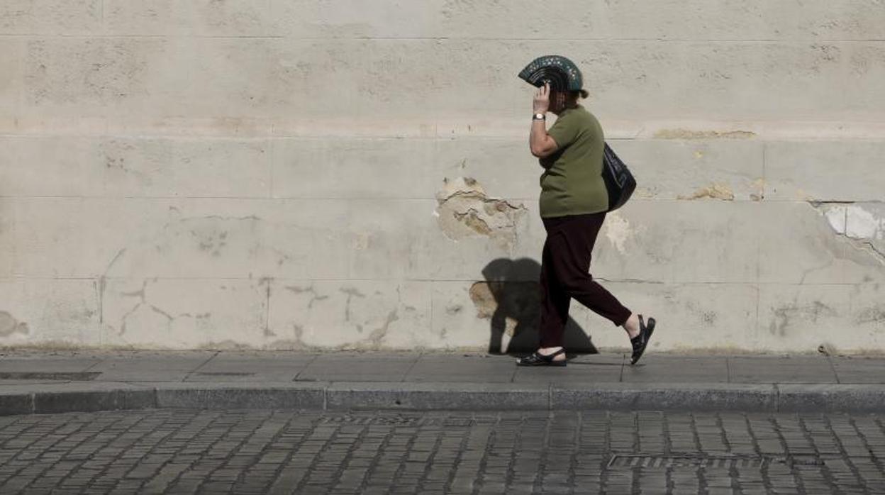 Una mujer se cubre con un abanico en una jonada de calor intenso en Córdoba