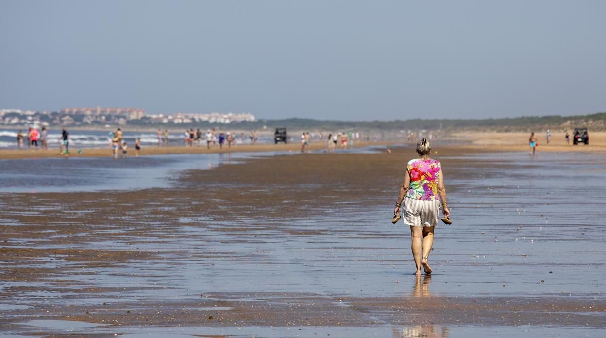 Paseantes en la playa onubense de Punta Umbría