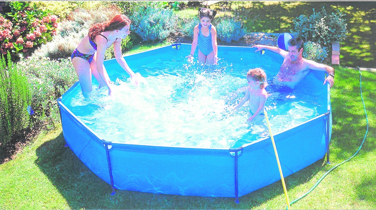 Una familia disfruta en una piscina de chapoteo en su jardín