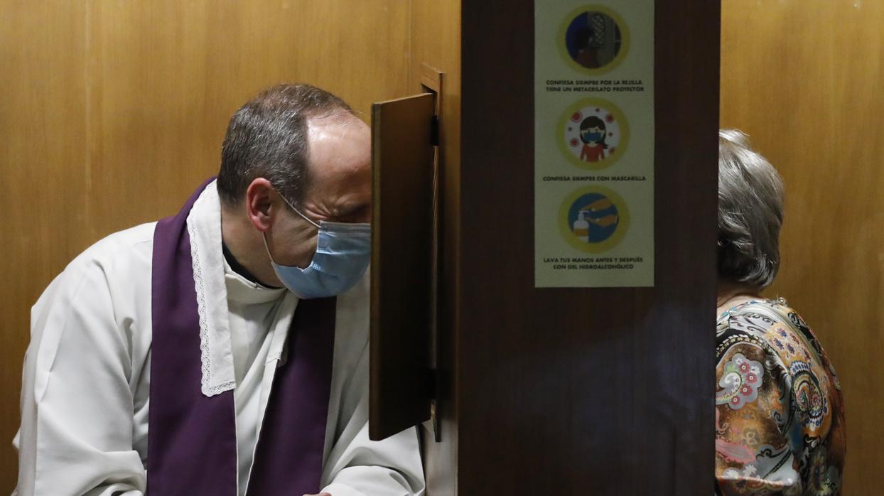 En la imagen, un sacerdote de la Iglesia de San Miguel en Córdoba confiesa empleando todas las medidas de seguridad