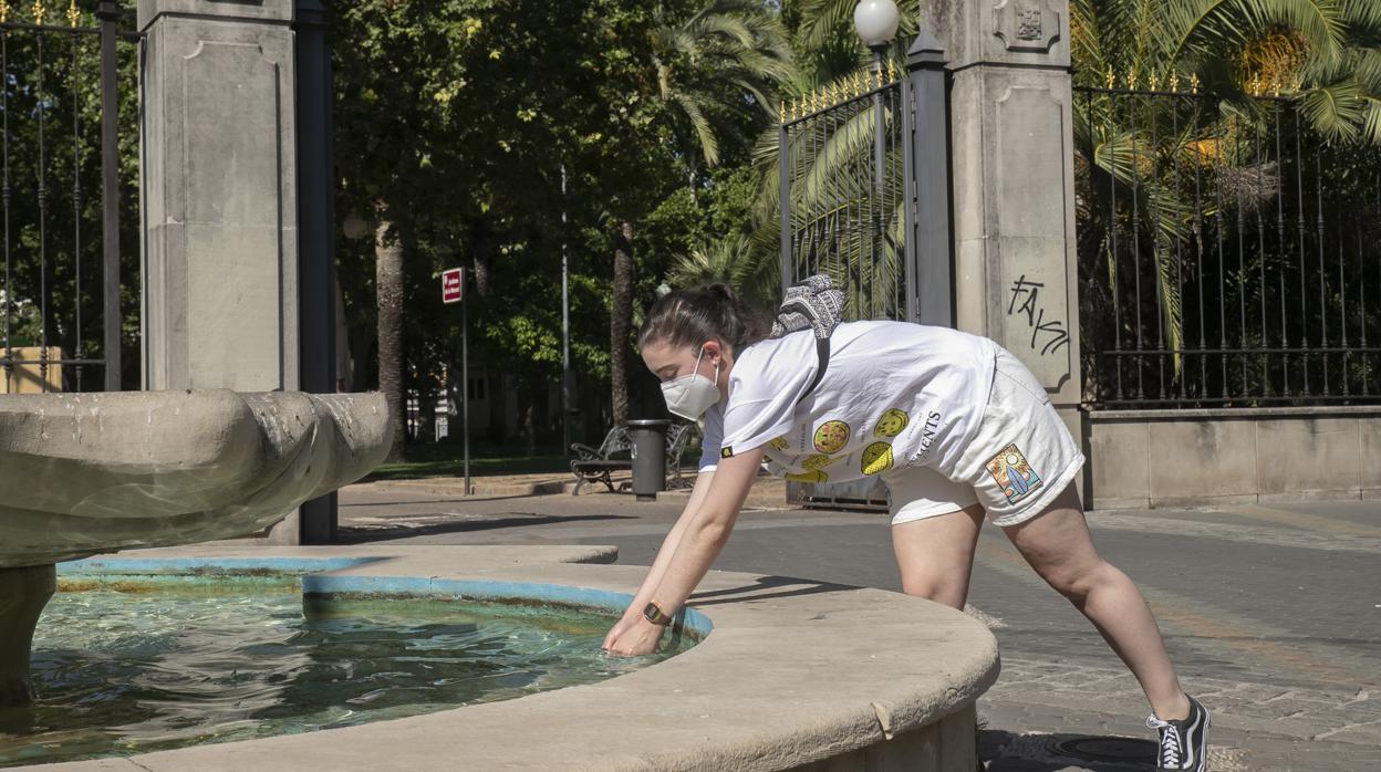 Una joven se refresca en una fuente de Córdoba